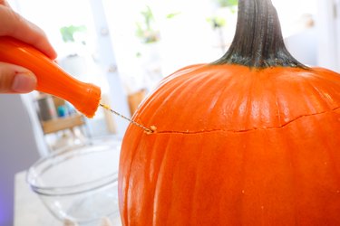 cutting the lid off a pumpkin