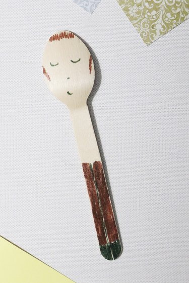 Drawing details on a spoon doll