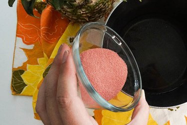 Strawberry Jell-O being poured into some hot water