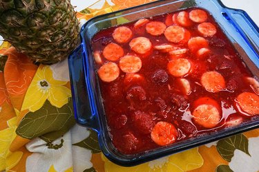 A blue dish holding the strawberry Jell-O salad on top of a fun 1970s napkin