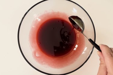 A mixture of strawberry and chocolate syrup in a clear bowl