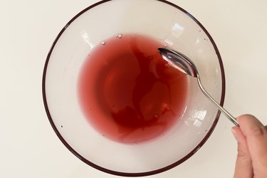 A mixture of fruit punch, corn syrup and chocolate syrup in a clear bowl