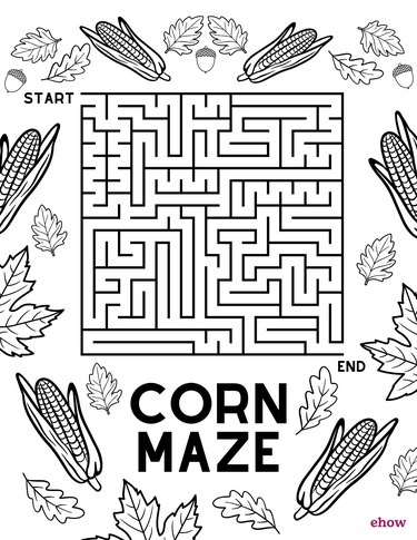 A coloring page featuring a maze activity and drawings of corn, leaves and acorns