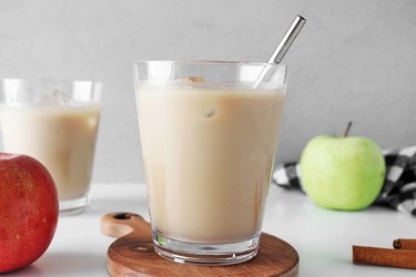 Iced apple crisp macchiato in a glass cup with metal straw