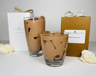 Two candles in clear glasses resembling iced brown coffee