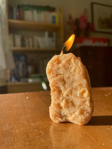 Lit candle shaped like a single chicken nugget
