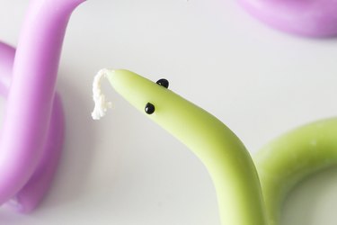Green twisted snake candle with black eyes made of hot glue