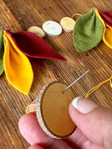 thread wooden discs onto cord