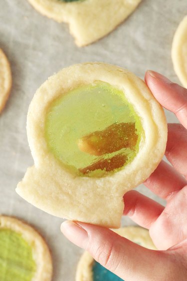 Hand holding crystal ball sugar cookie with green candy center