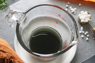 Black candle wax in a measuring cup