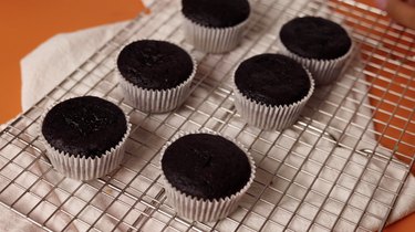 Baked cupcakes cooling on a wire rack