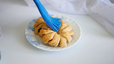 brushing apple pastry rings with butter