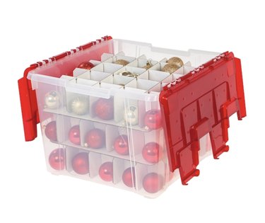 Transparent ornament storage box with red lid and little cubbies for housing ornaments.