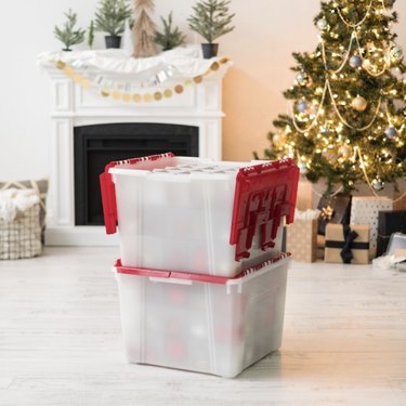 Transparent storage box with red lid in front of Christmas tree