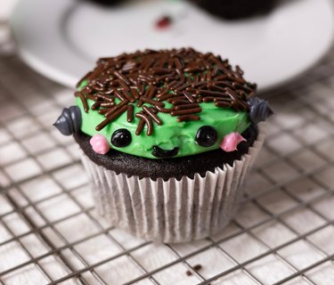 A single Frankenstein cupcake against a wire baking tray