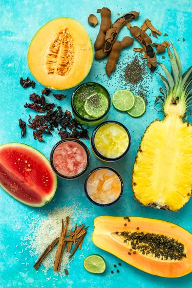 A colorful display of chopped fruits and aguas frescas