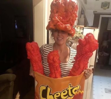 Woman wearing a costume of a bag of reddish orange Hot Cheetos