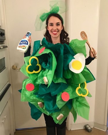 Woman wearing a costume of a salad in various shades of green