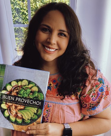 Ericka Sanchez holding up her cookbook
