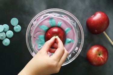 Dipping apple into melted candy