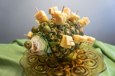 Cheese and pineapple spears placed into a pineapple