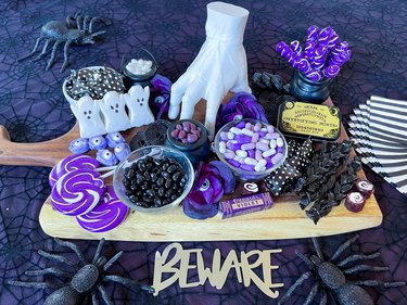 Candy spread filled with purple and black sweets on a wooden board