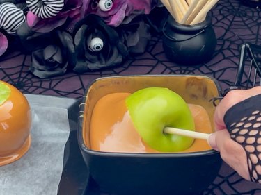Twirling the apple in melted caramel