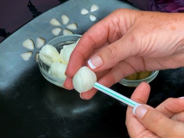 hollowing out the center of a mozzarella cheese ball with a straw