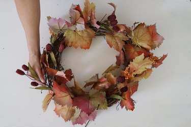 Tucking a thistle stem into the fall wreath