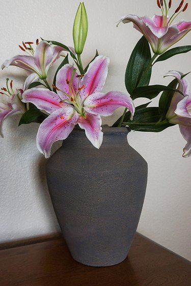 Lilies sit in a gray baking soda paint vase