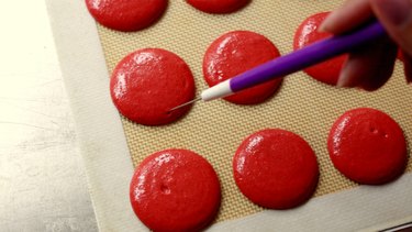 Popping air bubbles on macaron shells.