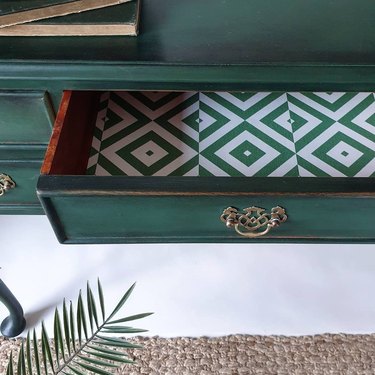 Green desk with open drawer lined with green and white pattern