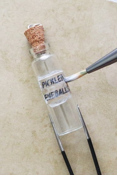 Applying potion label on bottle pendant