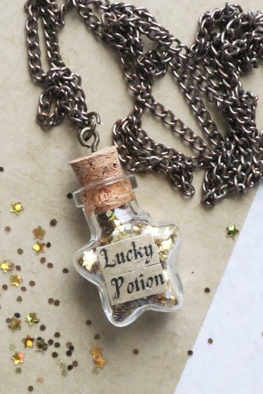 Star-shaped potion bottle necklace filled with gold glitter