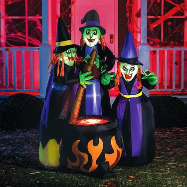 Three inflatable witches stirring a cauldron