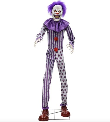 Creepy clown with purple hair and white and purple costume.