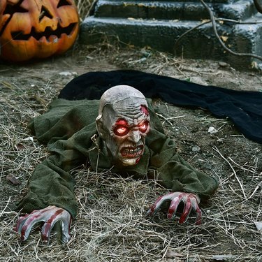 Zombie with light-up eyes laying on ground