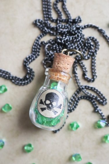 Glass bottle pendant filled with green crystal beads