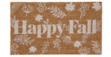 Coir doormat with white leaf motifs and the phrase "Happy Fall" in white bold lettering.