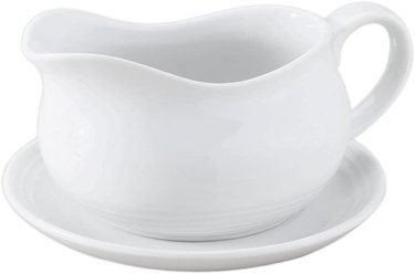 An elegantly curved, white porcelain gravy boat on a saucer