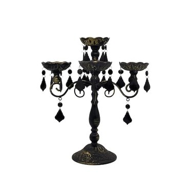 Black three-candle candelabra with dangling beads and a gold patina finish.