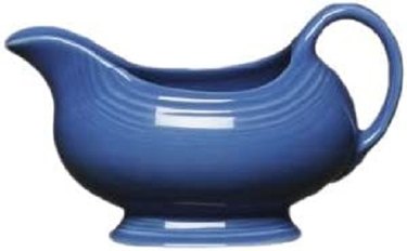 A blue ceramic gravy boat with a steep pour spout and shiny glaze