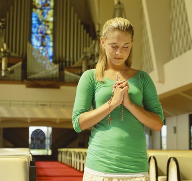close-up of a teenage girl praying in a church