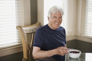 Man with bowl of berries and cream