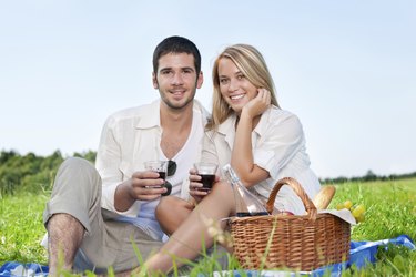 Picnic young happy couple celebrating with wine