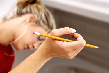 close-up of a woman's hand holding a rubber tip pencil