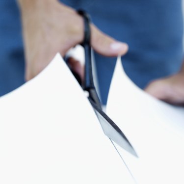 close-up of a person's hand cutting wallpaper