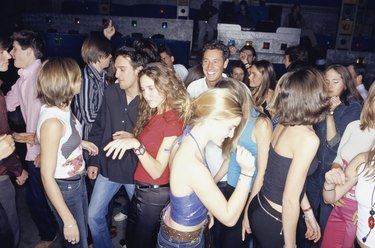 Large group of young adults dancing in club