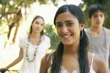 Teenage girl (16-18) smiling, portrait, friends in background