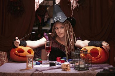 Halloween casino. Witch with smoking pipe and pumpkins.